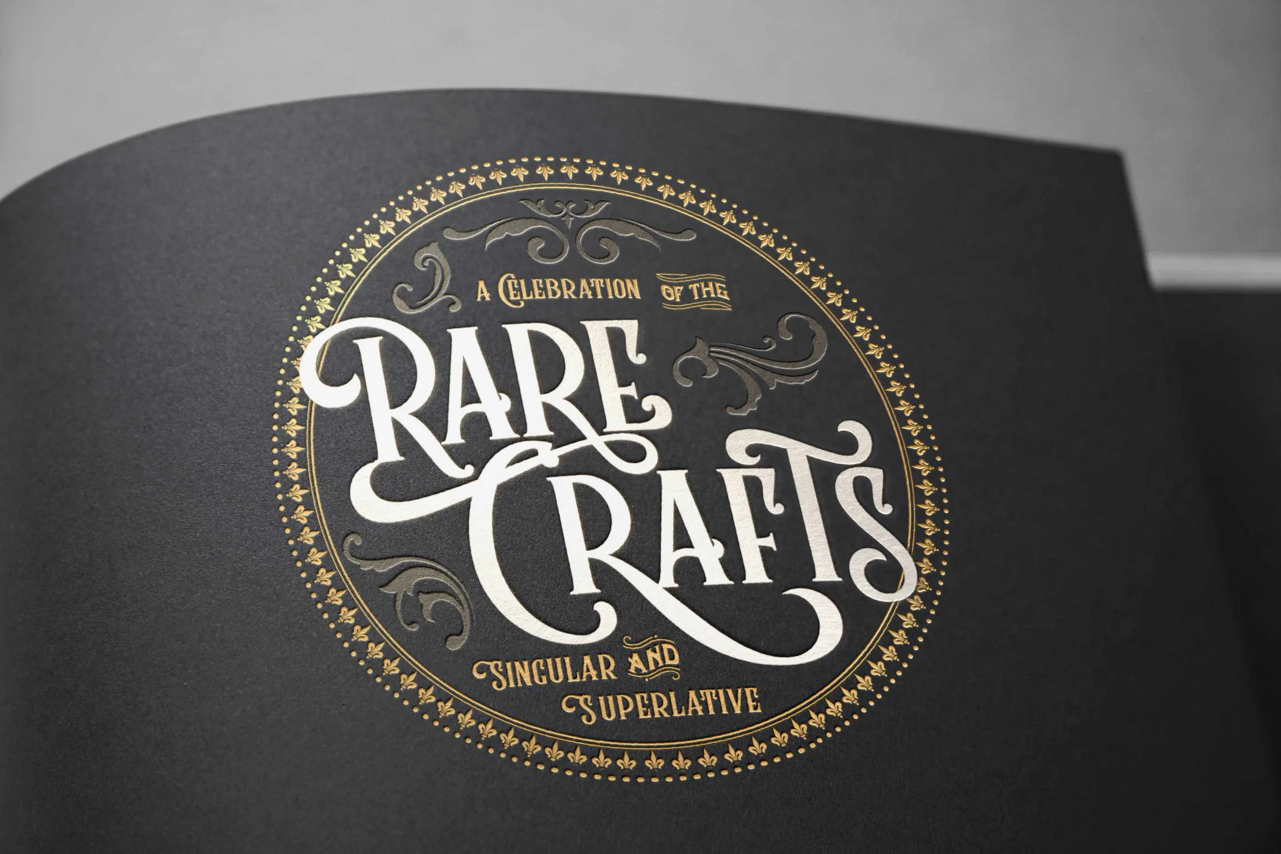 Custom event brochure cover for "A Celebration of the Rare Crafts, Singular and Superlative" featuring ornate Victorian-style typography with gold foil and silver detailing on black stock, designed for a Balvenie scotch tasting event.
