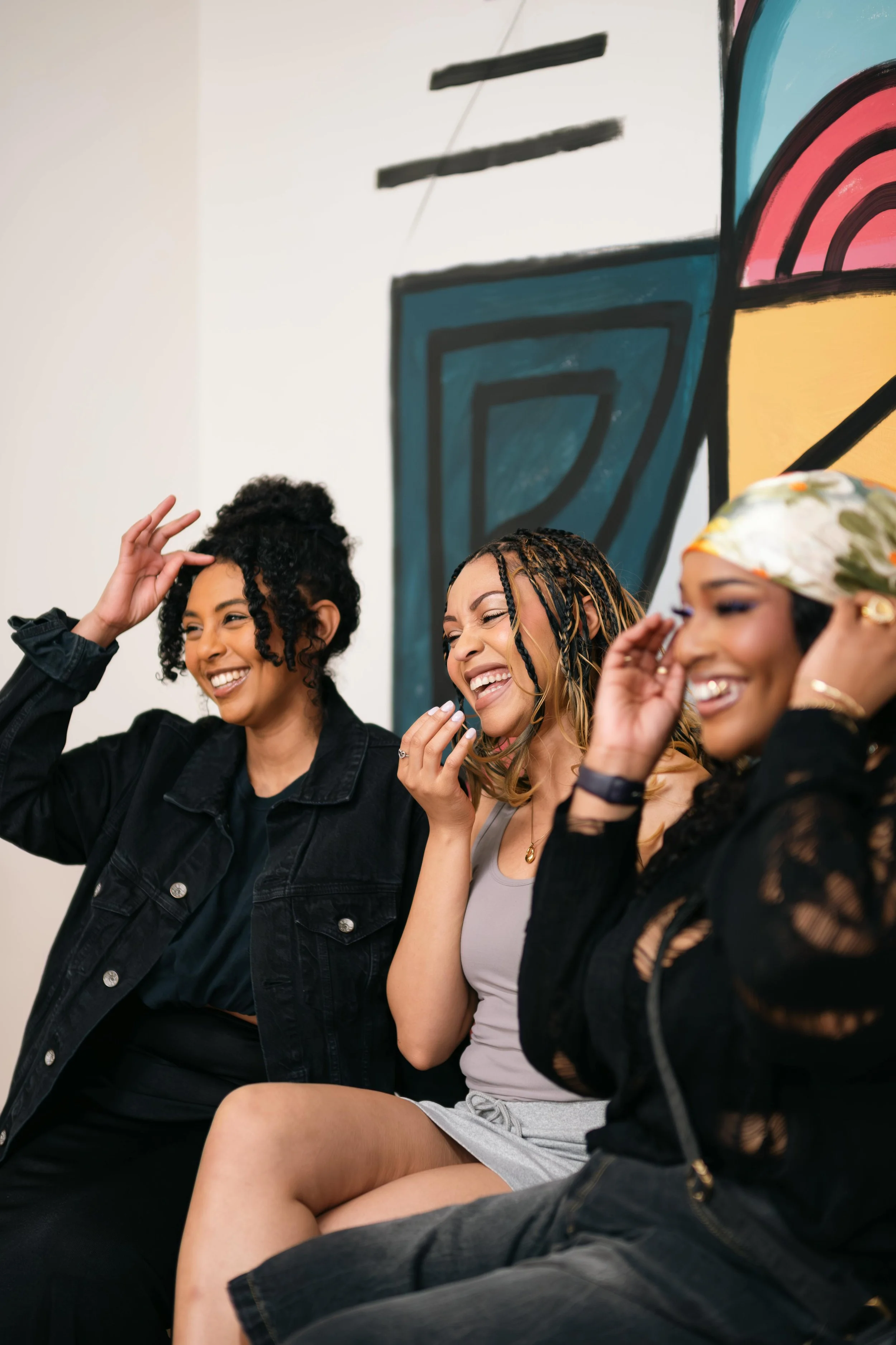 Three women sitting side by side, all smiling and enjoying themselves.