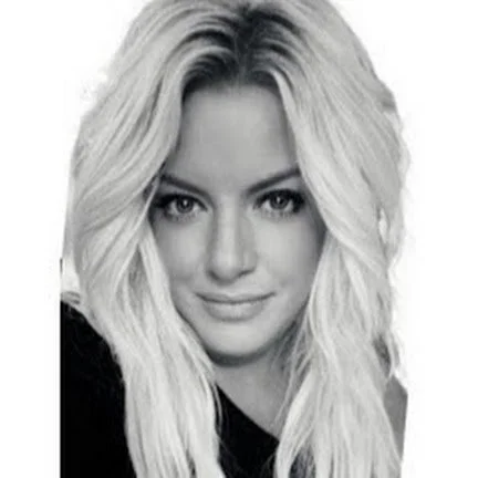 Black and white close-up portrait of a woman with long wavy blonde hair and a subtle smile.