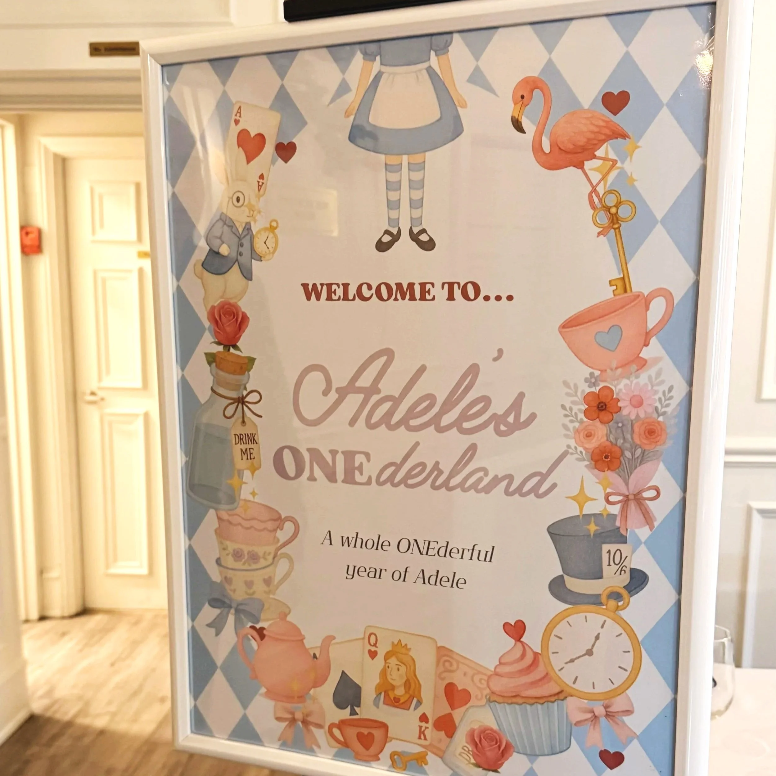 Decorative poster with illustrations of a girl with a clock, a bunny rabbit holding a pocket watch, a pink flamingo standing on one leg, a teacup with a bow, a cupcake, flowers, and hearts, with the text "Welcome to..." and additional words partially