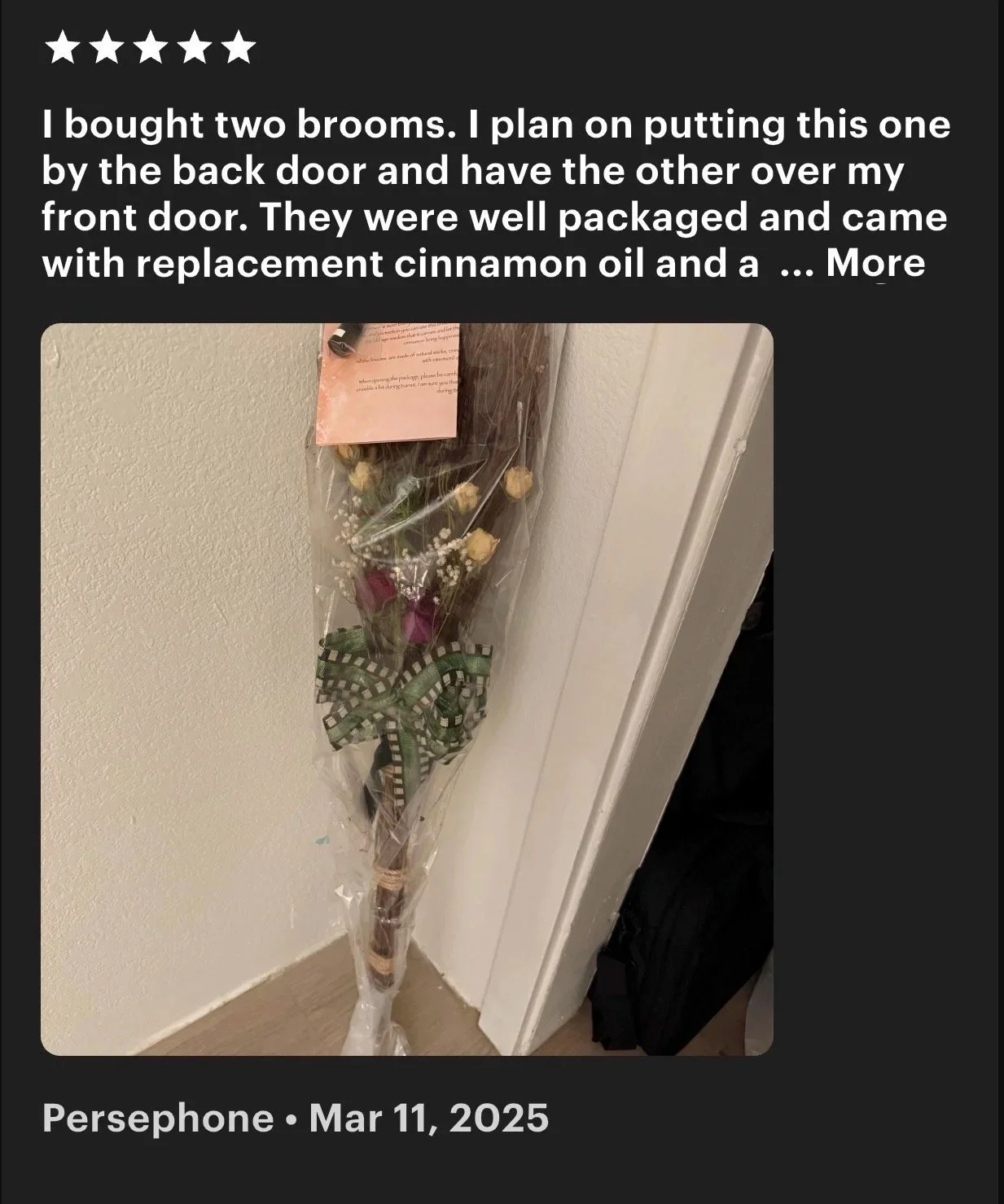 A wrapped bouquet of flowers hanging on a wall near a door, decorated with a green and white plaid ribbon.