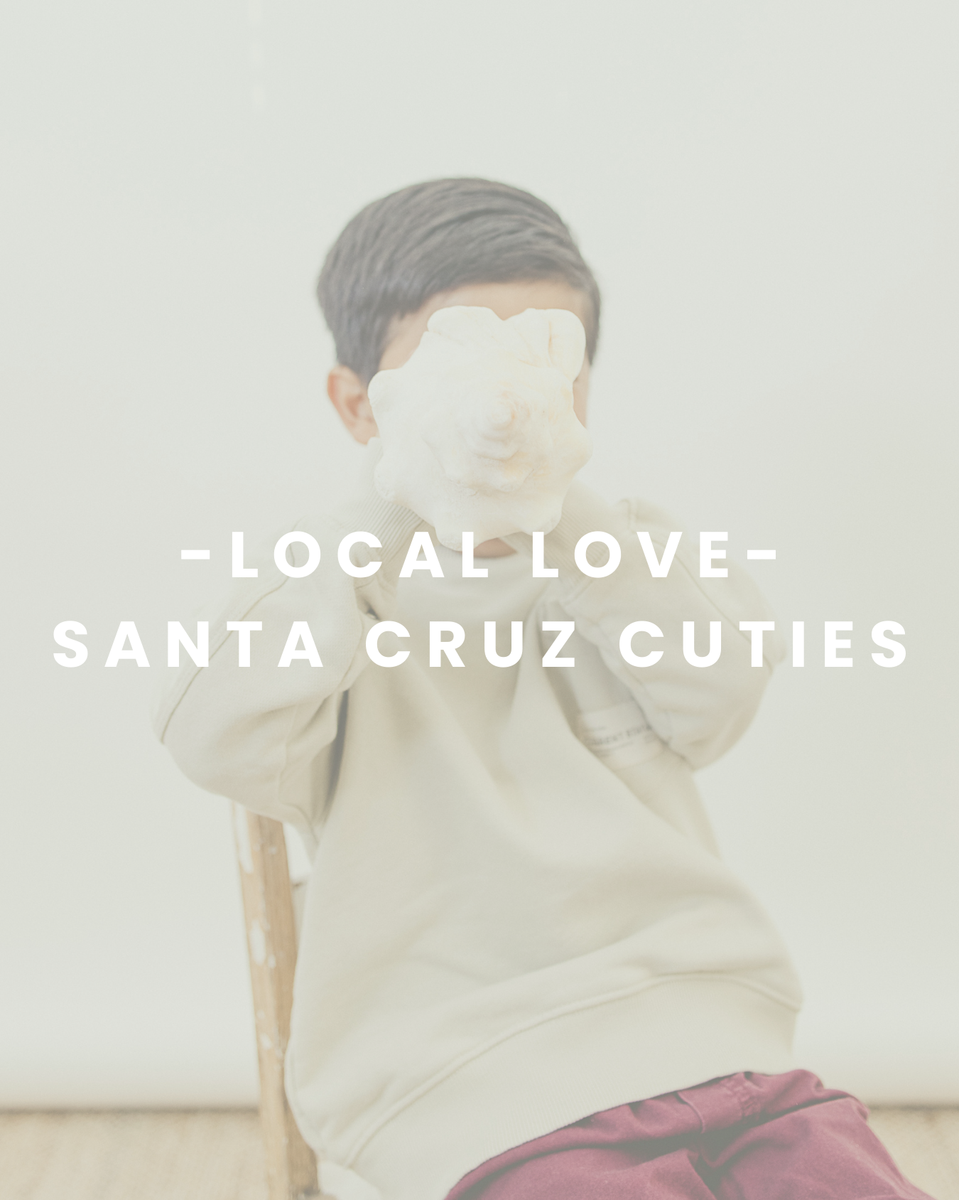 A little boy holding a large seashell in front of his face, with text overlay that reads "Local Love - Santa Cruz Cuties" for Hand It Down Kid's Resale Shop in Santa Cruz, CA.