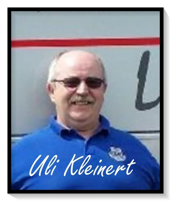 Ein Mann mit Brille und blauer Polo-Hemd steht vor einem Fahrzeug, Text im Bild lautet 'Uli Kleinert'.