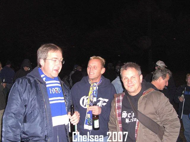 Drei Männer feiern bei einem Fußballspiel, tragen Chelsea- und Fußball-Fanartikel, im Jahr 2007.