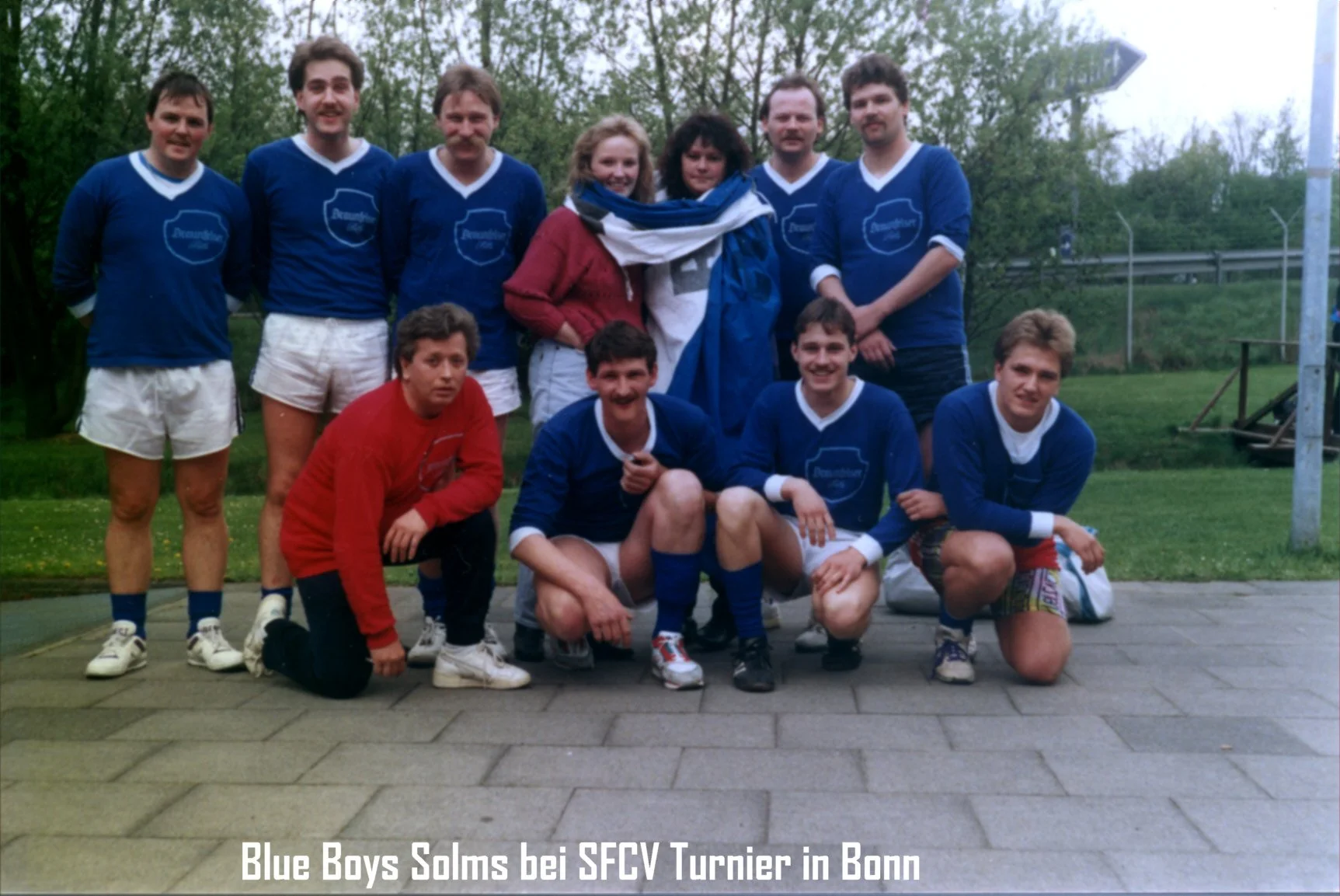 Gruppenfoto der "Blue Boys Solms" bei einem Turnier in Bonn, die Fußballmannschaft trägt blaue Trikots und ist auf einem Sportplatz.