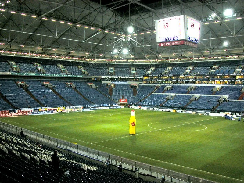 Leeres Fußballstadion mit einem in der Mitte stehenden onenote-ähnlichen Helm und einer Videoleinwand im Hintergrund.