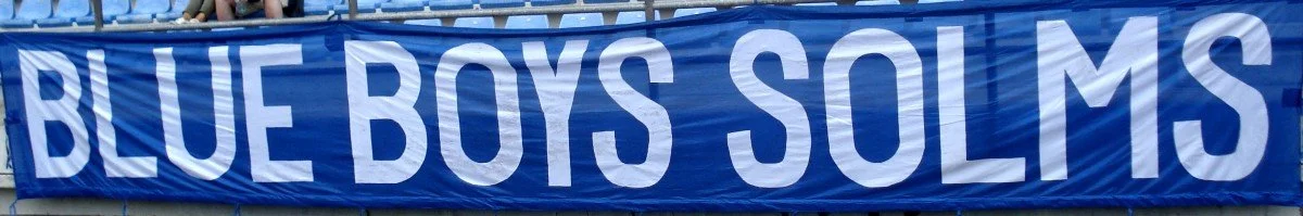 Großes blaues Banner mit weißen Buchstaben, auf dem steht 'BLUE BOYS SOLMS'.