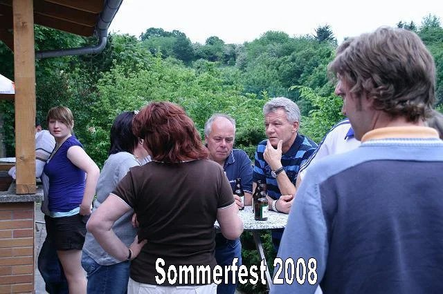 Gruppe von Menschen beim Sommerfest 2008 im Freien, im Hintergrund grüne Bäume.
