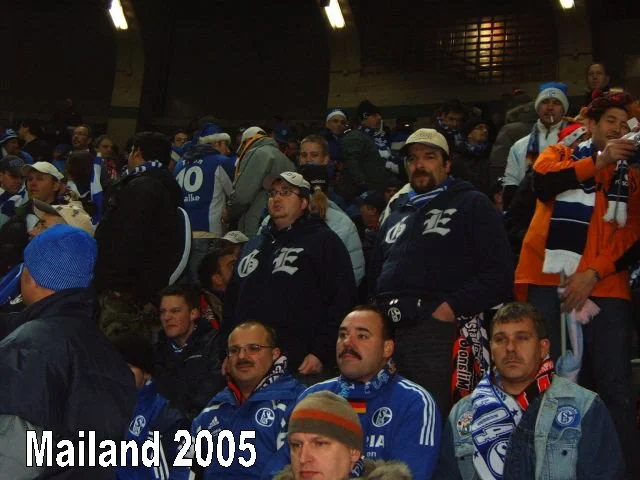 Fußballfans in einem Stadion, viele tragen Schals und Trikots des FC Schalke 04, vermutlich beim Auswärtsspiel in Mailand 2005.