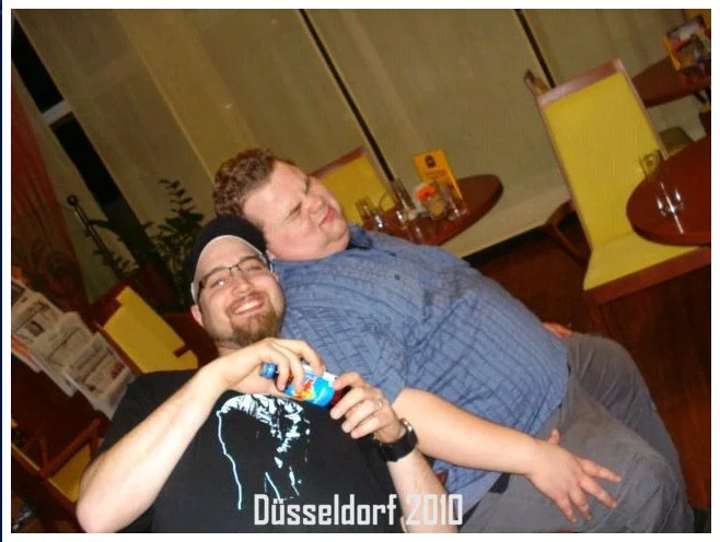 Zwei Männer lachen und sind entspannt in einem Restaurant oder Café in Düsseldorf im Jahr 2010.