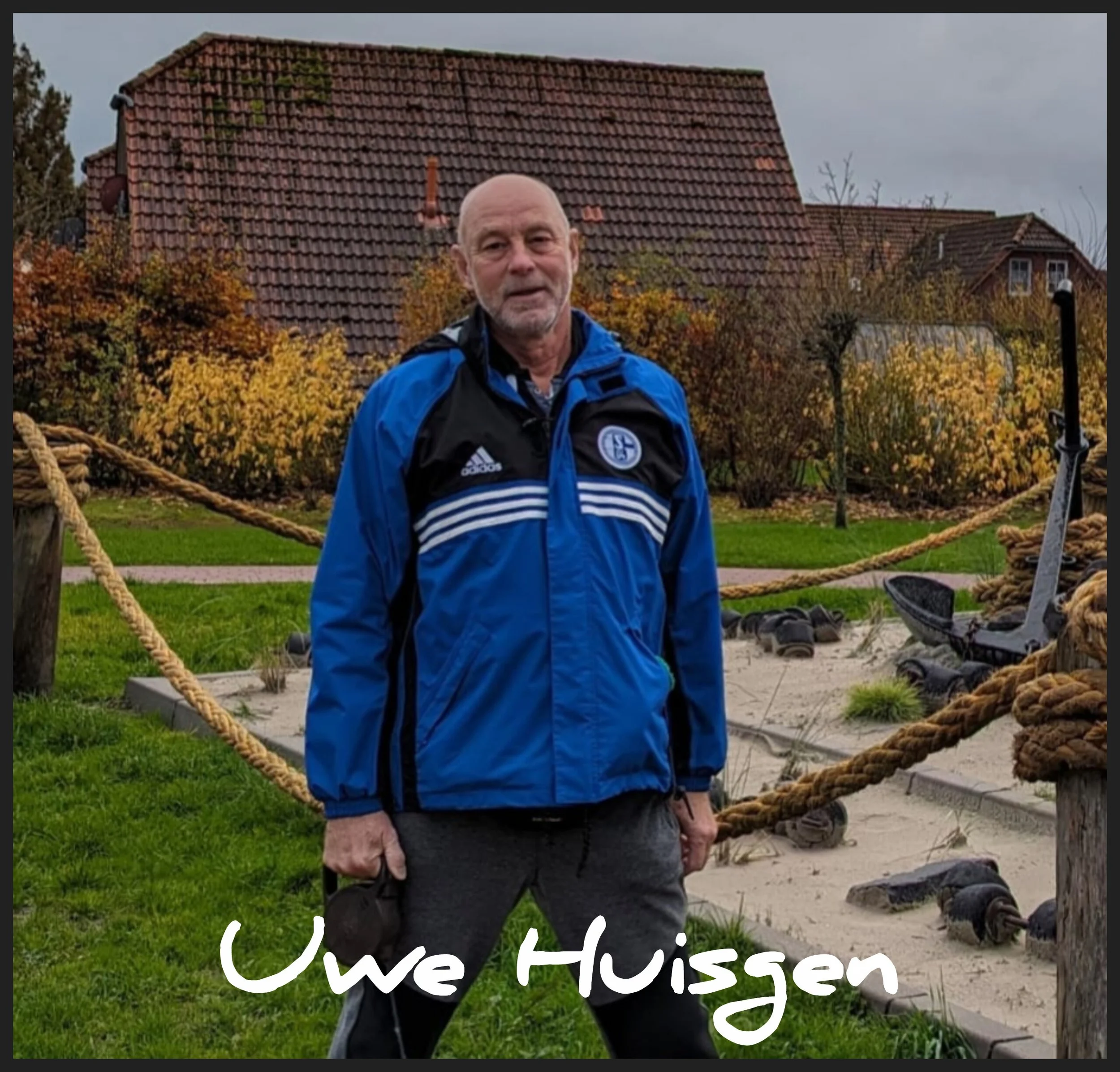 Ein älterer Mann mit Glatze, Brille und grauem Bart, trägt eine blaue Jacke, steht vor einem Garten mit Büschen mit herbstlichen Blättern. Auf dem Bild steht in weißen Schrift: "Uwe Hissen".