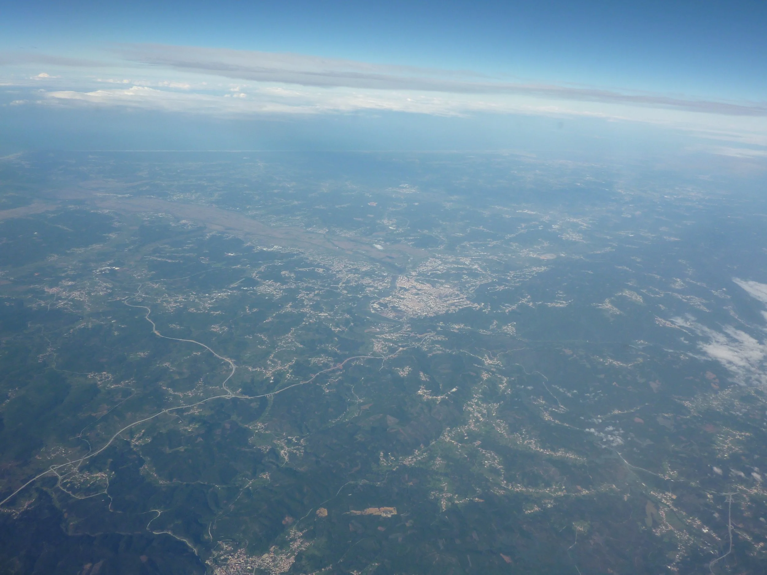Luftaufnahme der Erde, die die Wolken und das Land darunter zeigt.