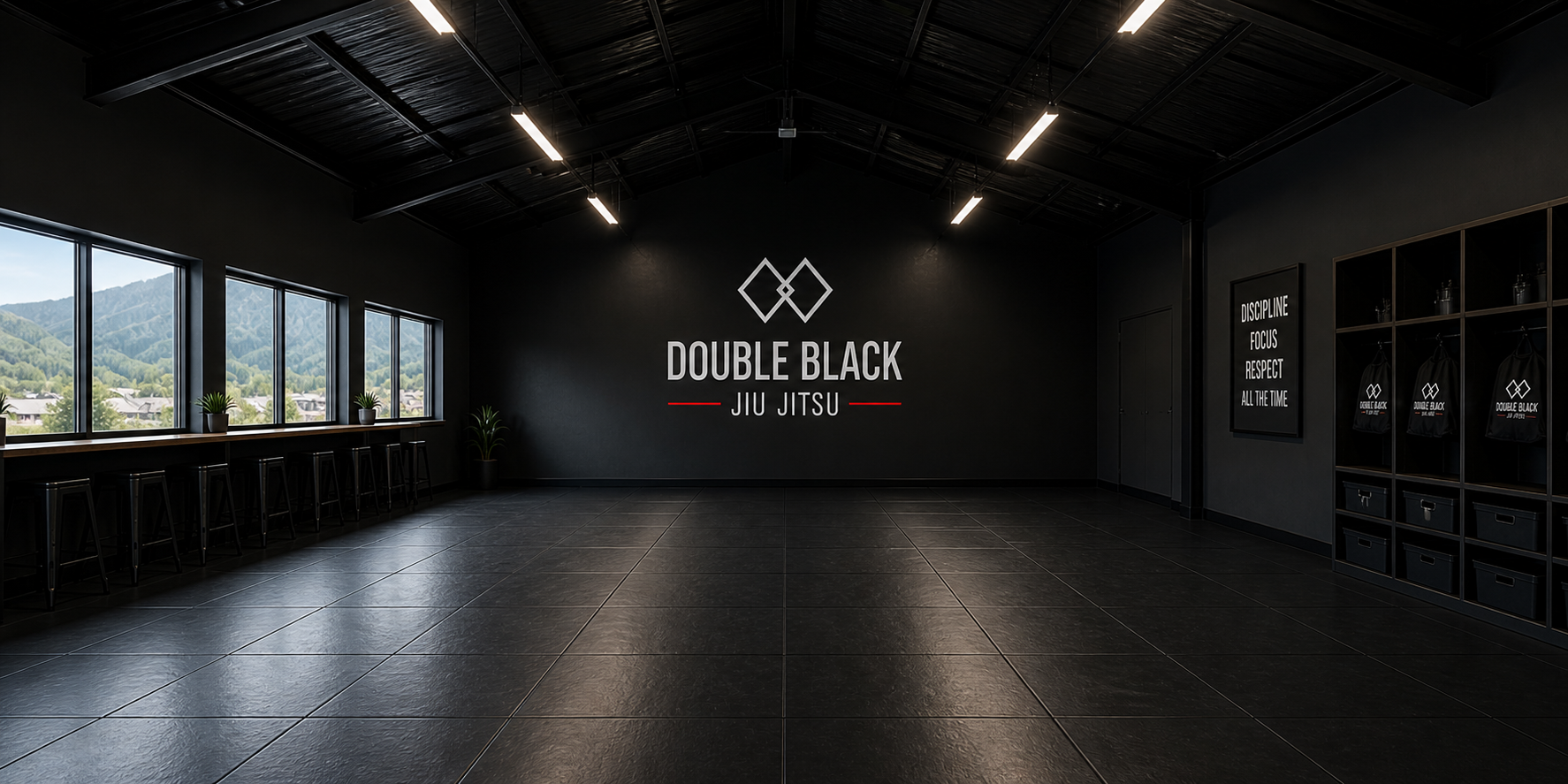 An indoor jiu jitsu gym with black walls and lighting. Large windows on the left show a mountain view. The center wall displays the logo and name 'Double Black Jiu Jitsu'. There are plants near the windows and a sign with practice guidelines on the right wall. Small storage lockers with gi bags are on the far right.