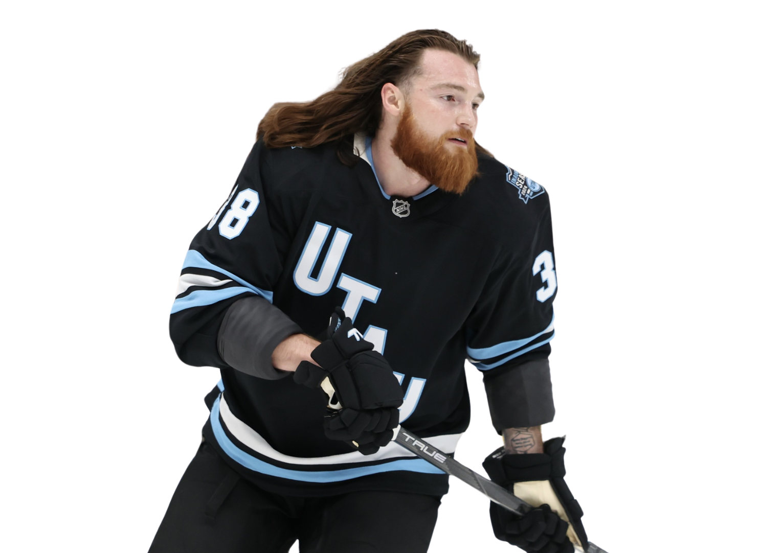 A male ice hockey player with long red hair and a beard, wearing a black jersey with the letters 'U T L' and the number 8, holding a hockey stick.