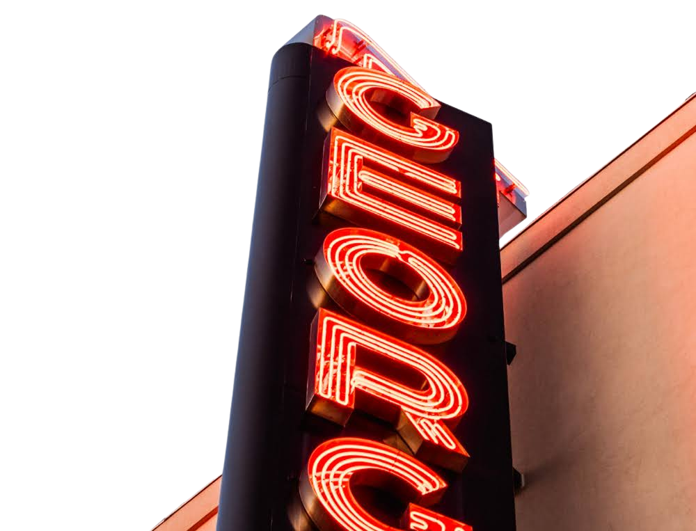 Close-up of a vertical neon sign that spells 'COFFEE' in red and white lights against a dark background.