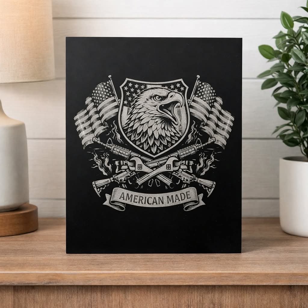 A black and white graphic of a shield with an eagle's head, American flags, rifles, and the words 'American Made' on a banner.