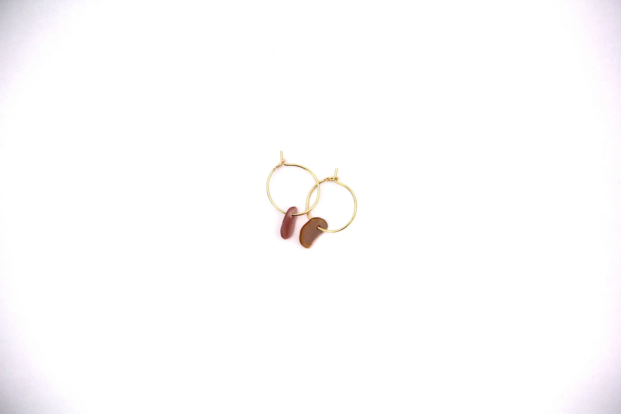Gold stainless steel seashell hoop earrings on white background.