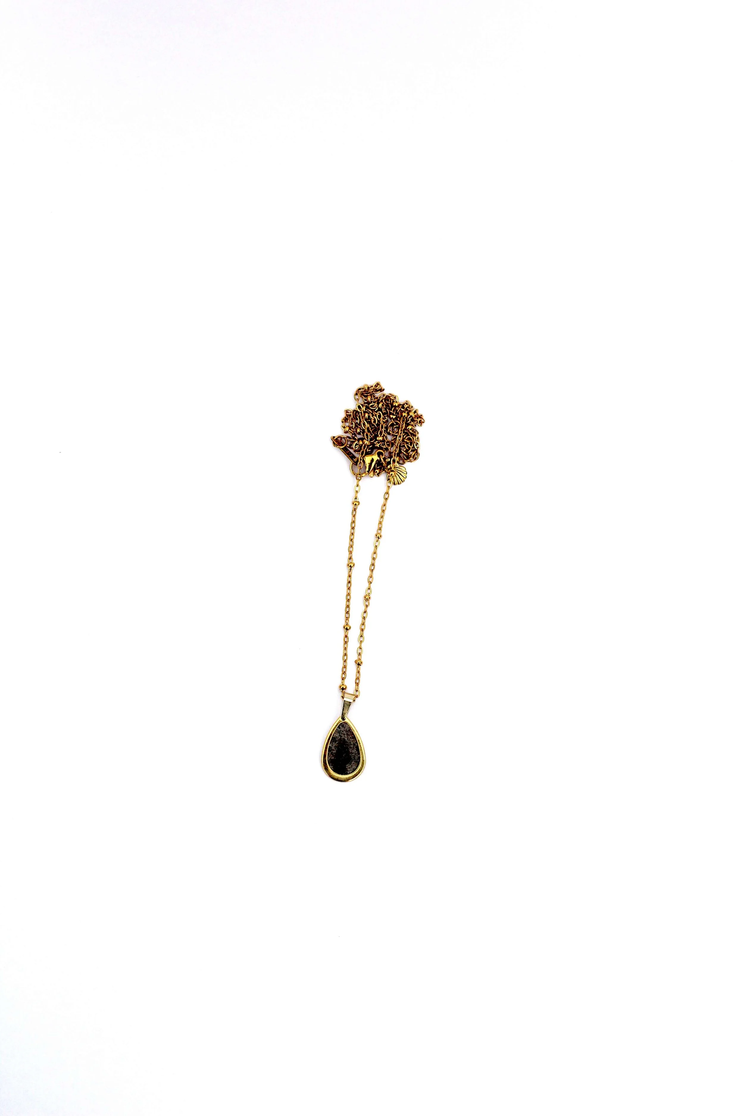 A genuine hand-collected beach sand pendant on an 18K gold-plated stainless steel cable chain necklace on a white background.