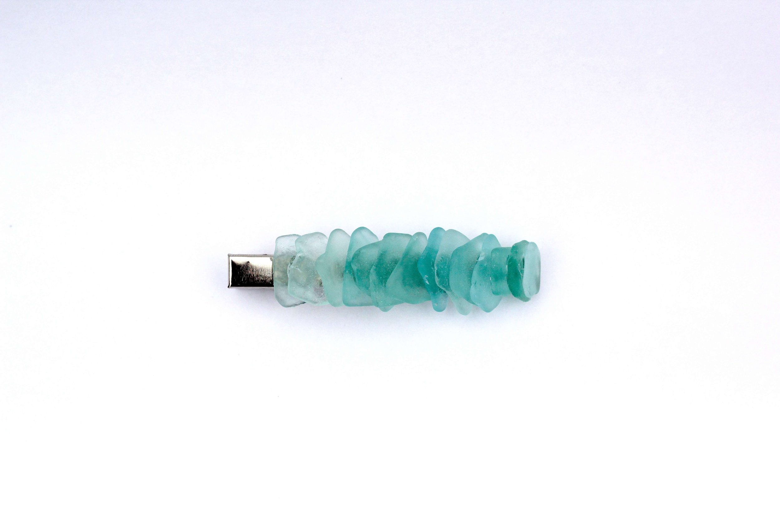 The front of a genuine ocean-tumbled sea glass silver hair clip on a white background.