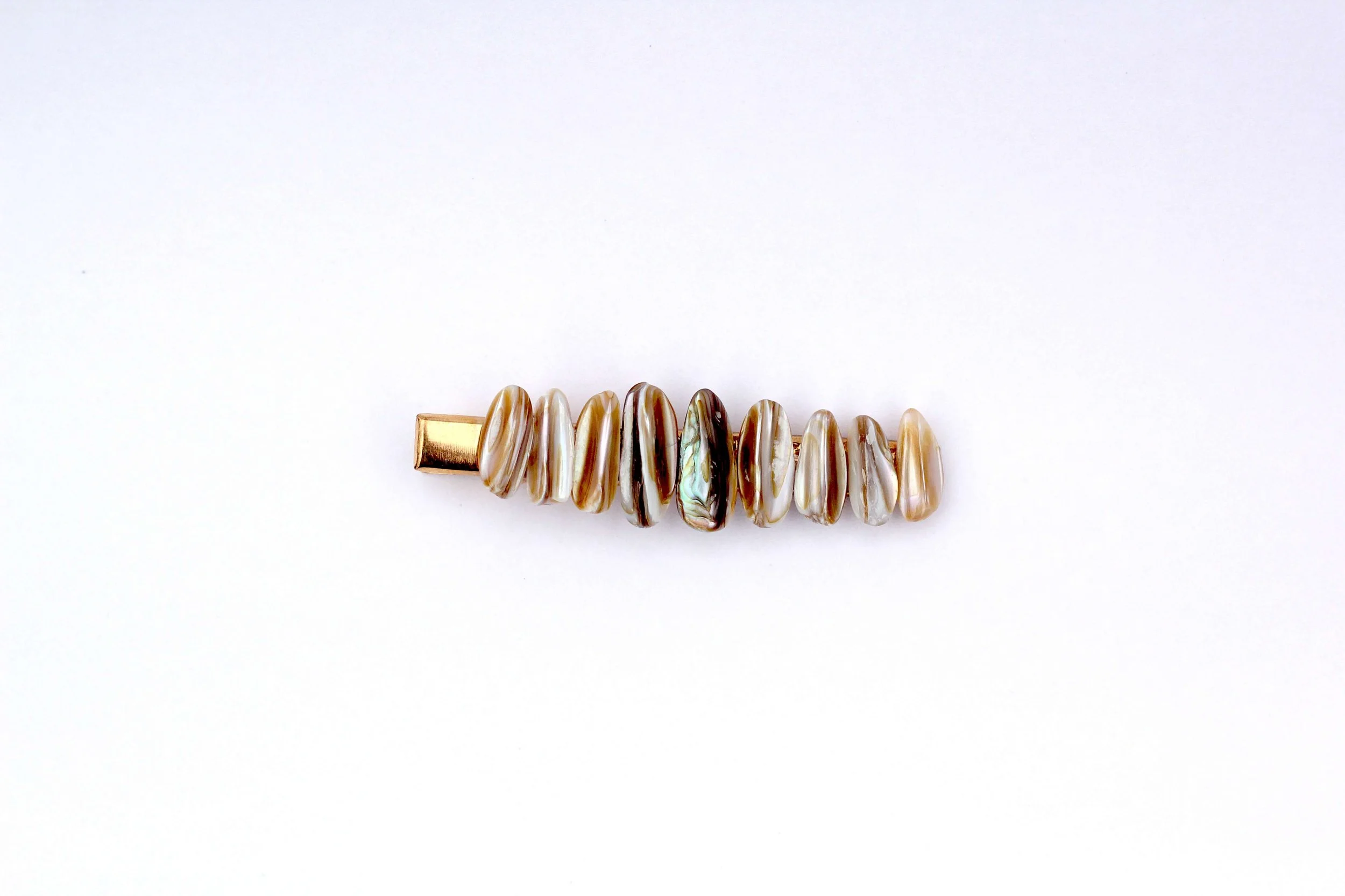 The front of a genuine seashell gold hair clip on a white background.