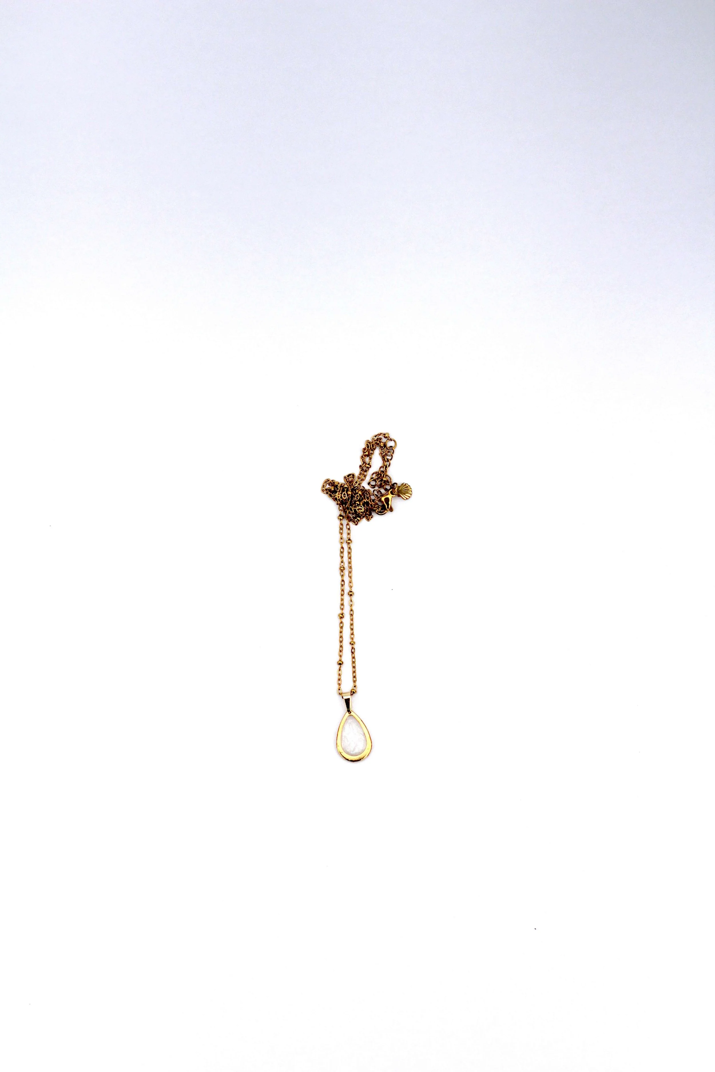 A genuine hand-collected sea salt pendant on an 18K gold-plated stainless steel cable chain necklace on a white background.