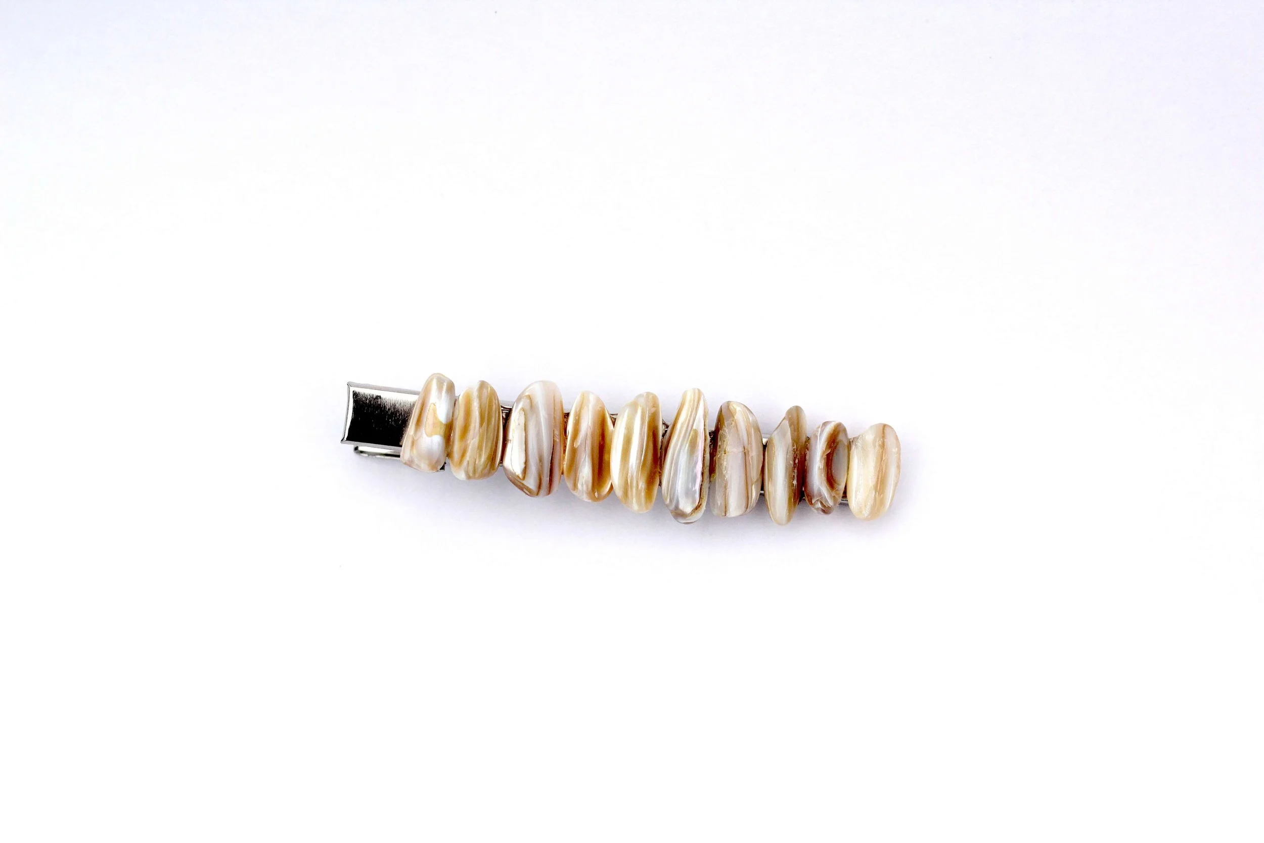 The front of a genuine seashell silver hair clip on a white background.
