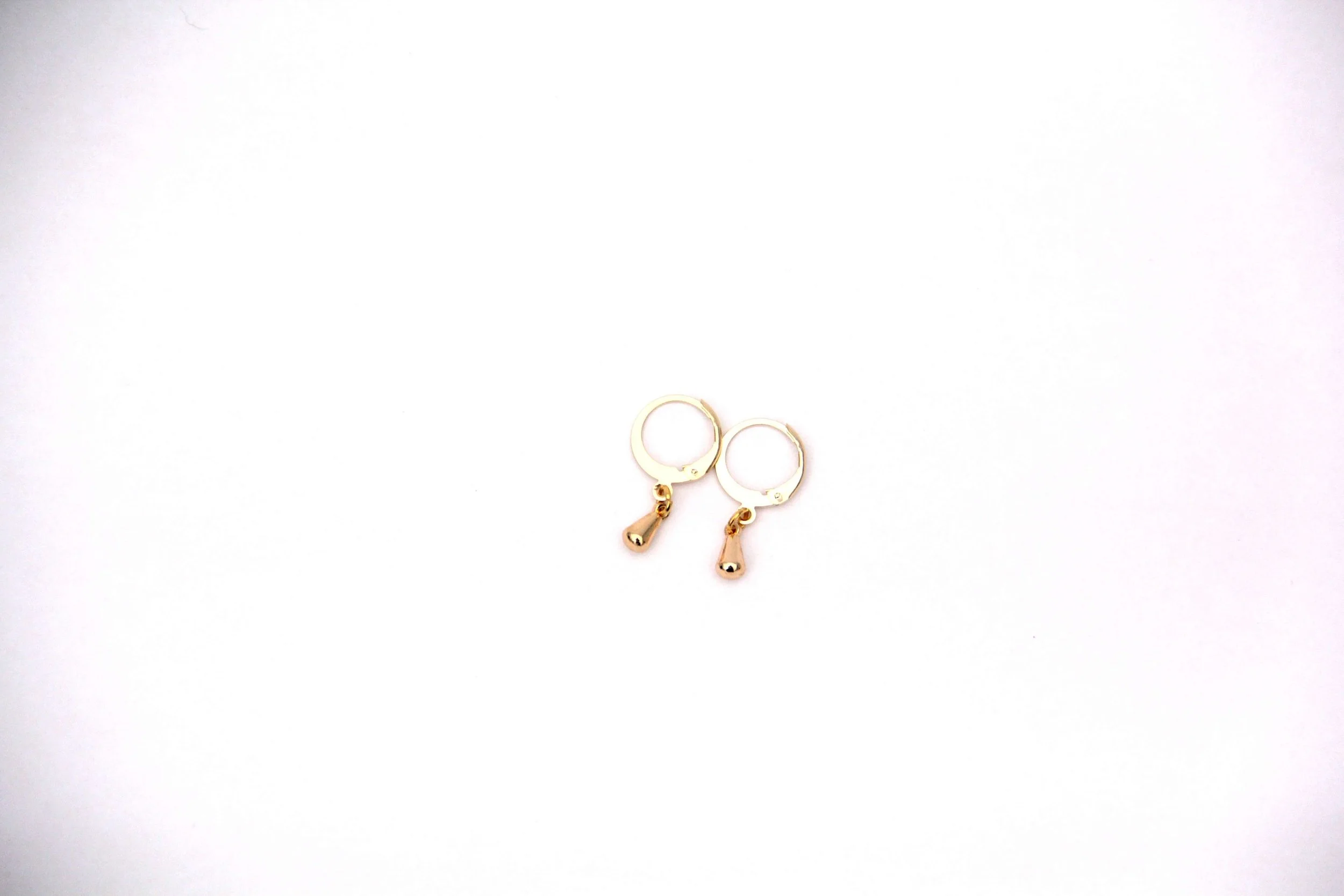 A pair of 18K gold-plated brass water droplet charm huggie hoop earrings on white background.