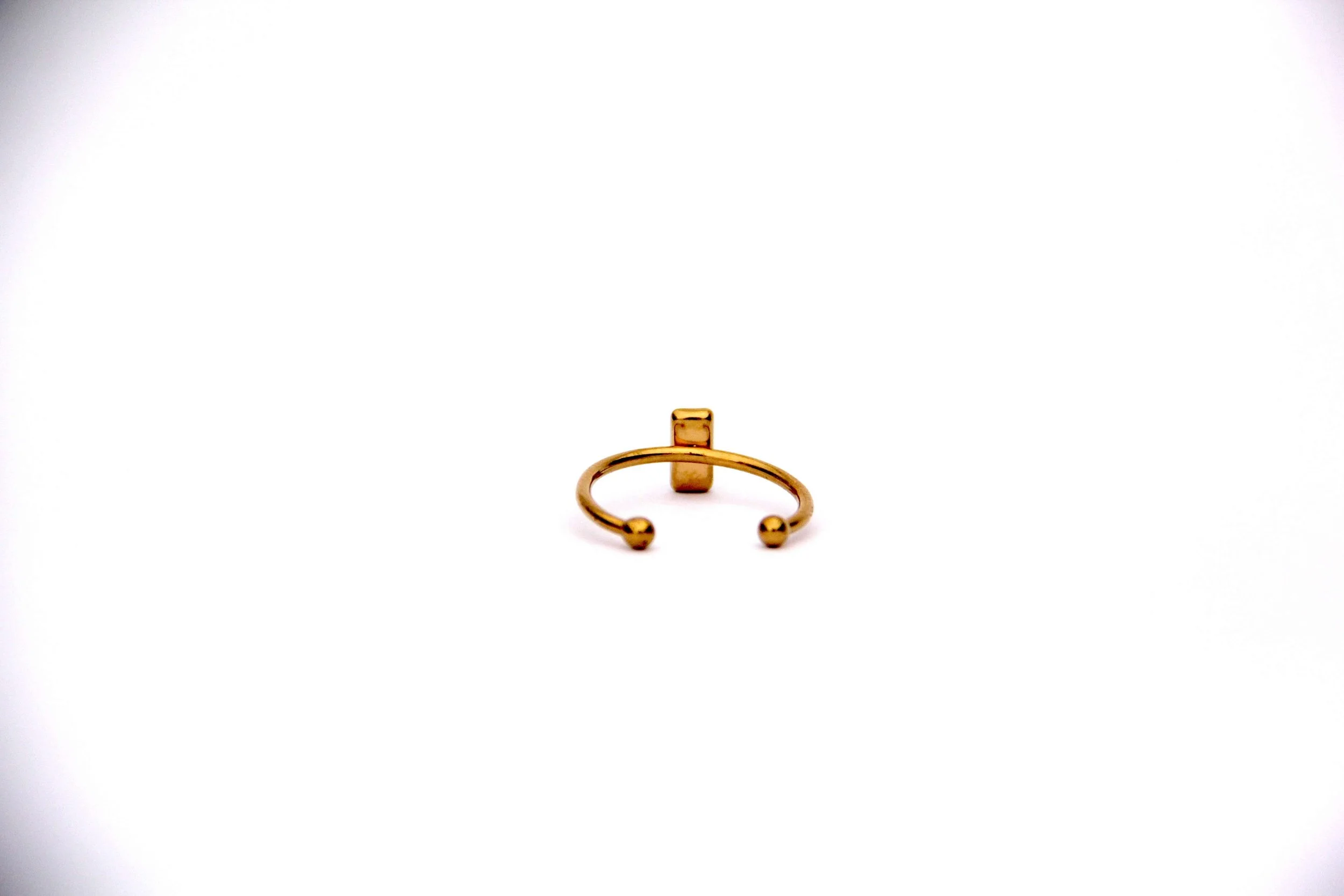The back of a genuine hand collected beach sand ring on a white background.