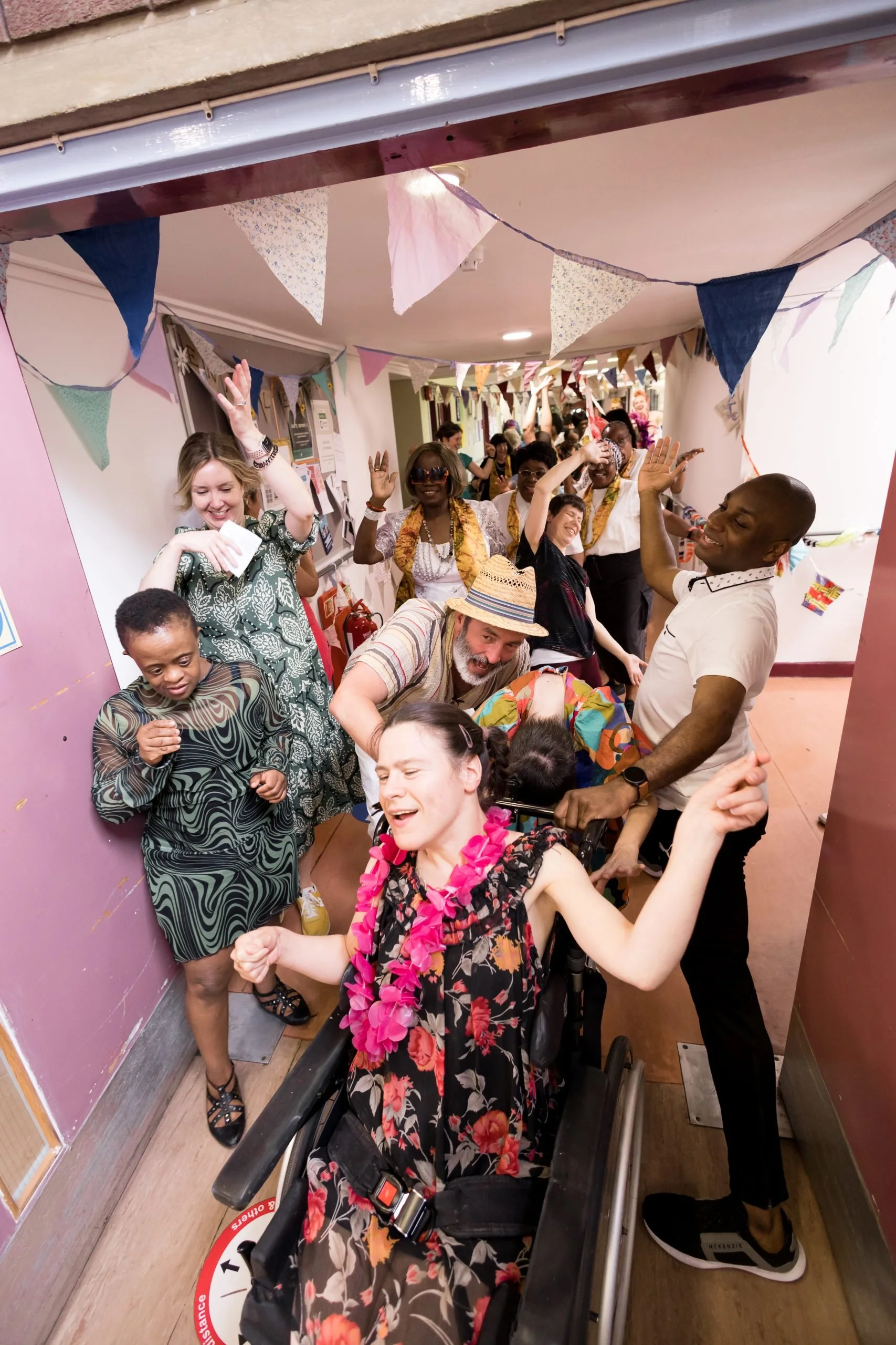 A group of people dance down the corridor together