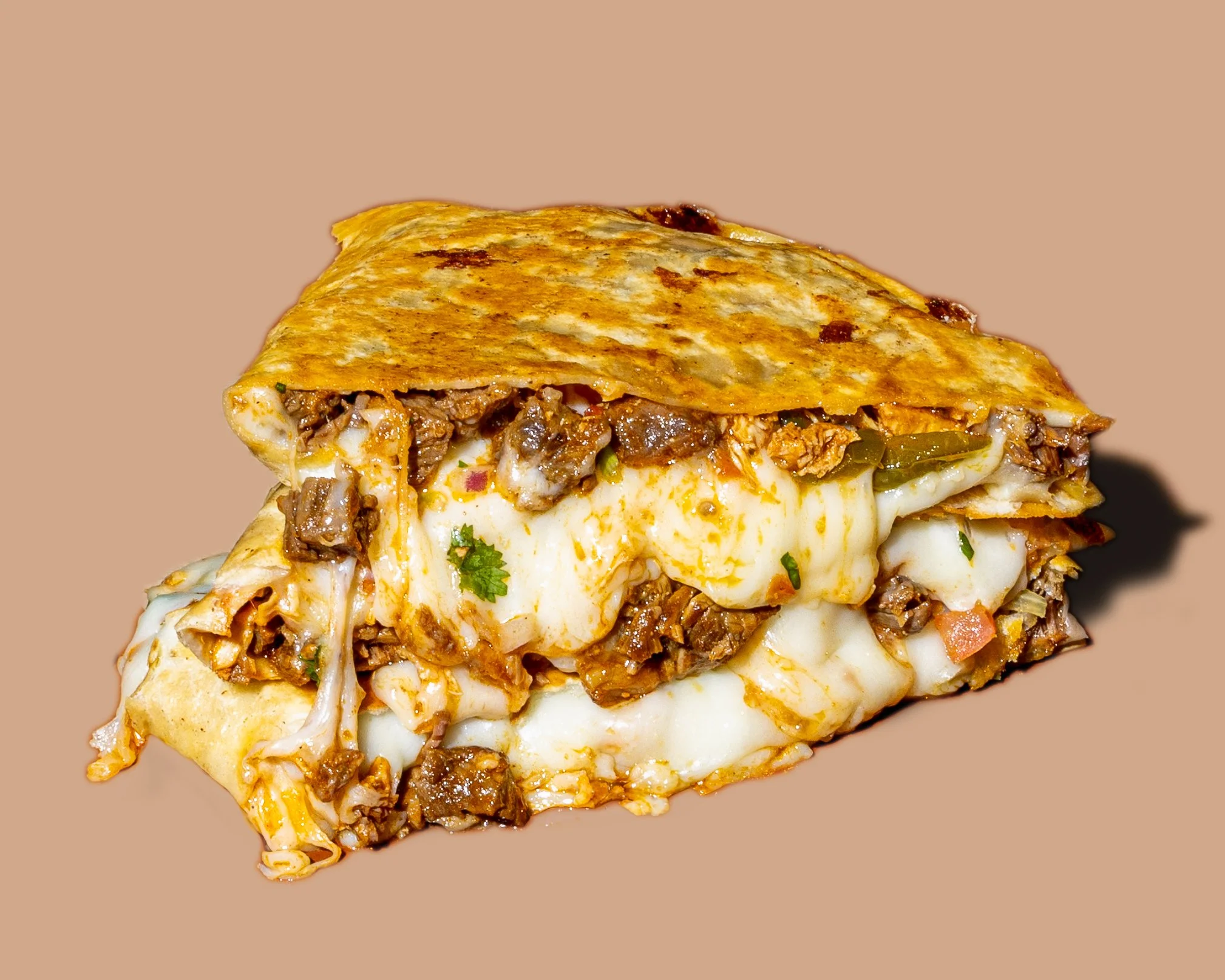 Close-up of a slice of meat and cheese stuffed quesadilla with melted cheese, seasoned ground beef, and green peppers, on a plain background.