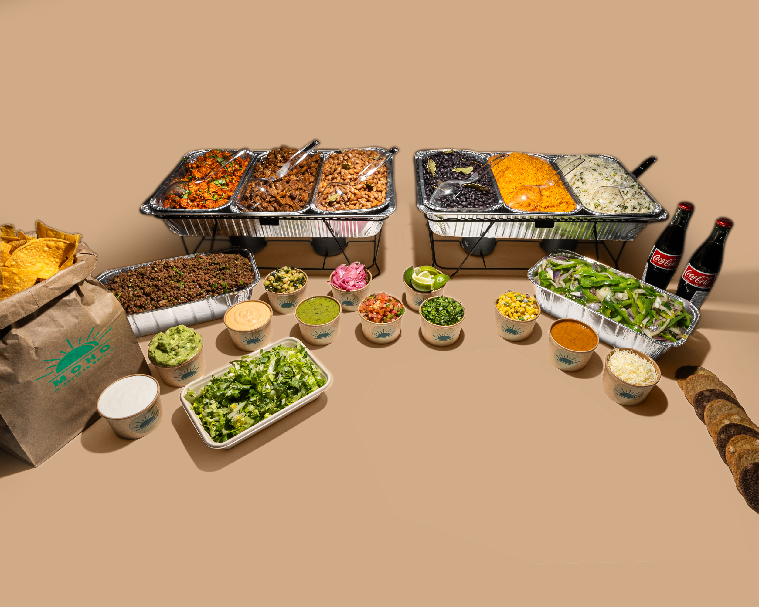 A variety of Mexican foods including beans, rice, salad, tortillas, and drinks on a table.