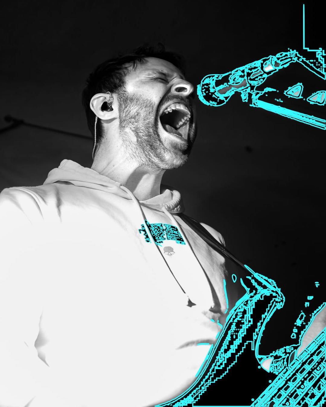 A man singing with his mouth open, wearing headphones and a hoodie, with digital blue graphic overlay of musical equipment.