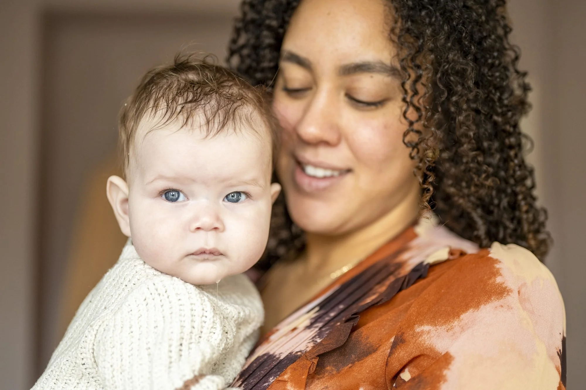 Mother holds her calm newborn tenderly