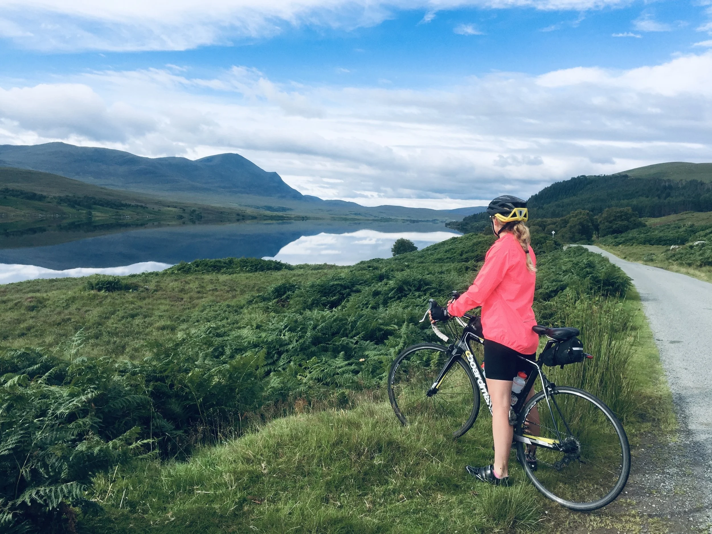 Sally Lygo cycling through a mountain landscape, reflecting her active lifestyle and love of outdoor adventure.