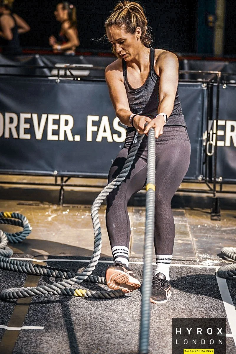 Sally Lygo performing a battle rope strength workout, reflecting her background in sport, fitness and active rehabilitation.