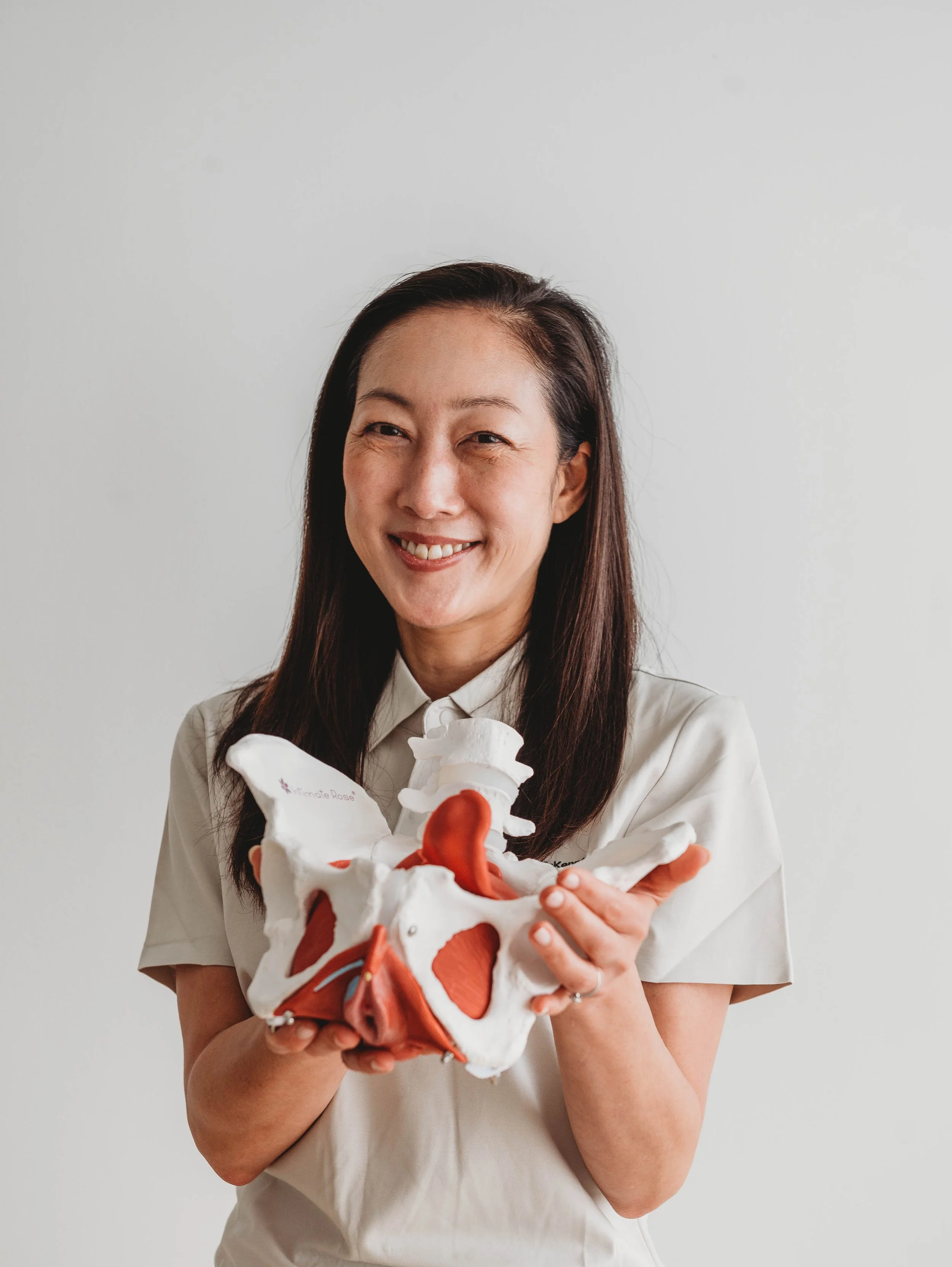 Sophia Park McKenna, Senior Physiotherapist with expertise in women’s health and pelvic floor physiotherapy, holding an anatomical pelvis model.