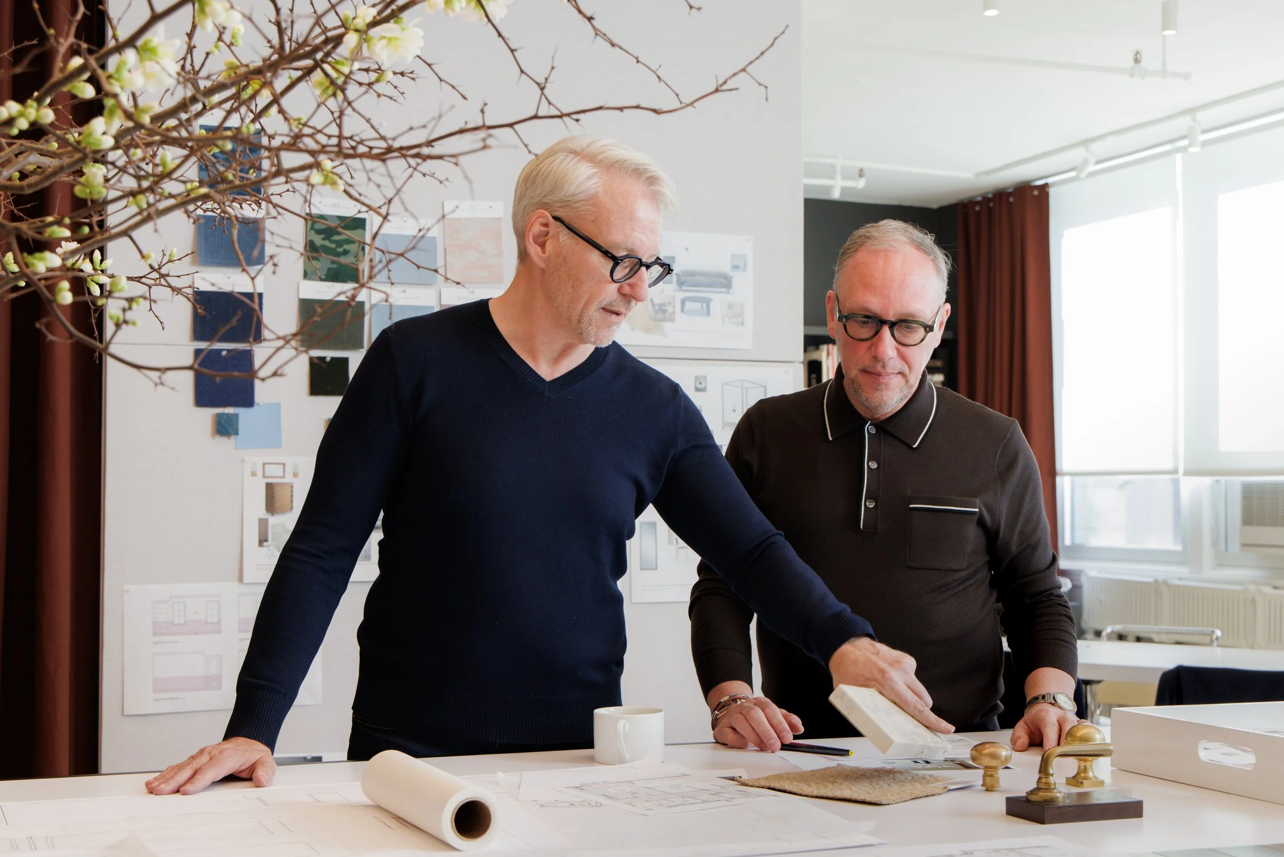 Interior designers William McIntosh and Martin Raffone reviewing plans and material samples at their New York City studio