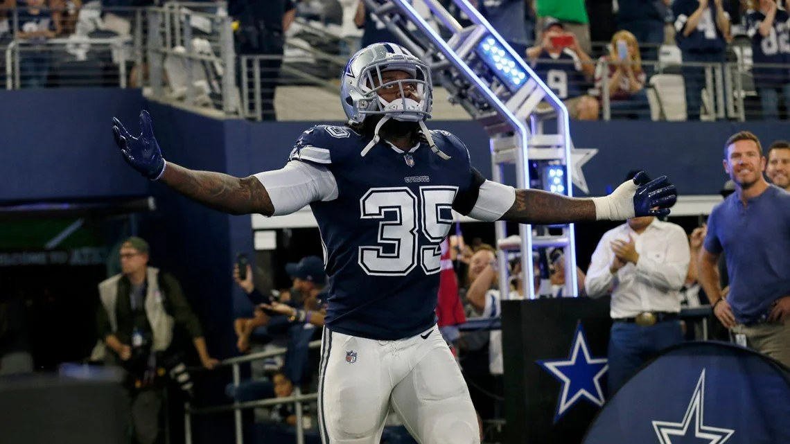 American football player, Kavon Frazier, from the Dallas Cowboys celebrating with arms outstretched during a game at AT&T Stadium.