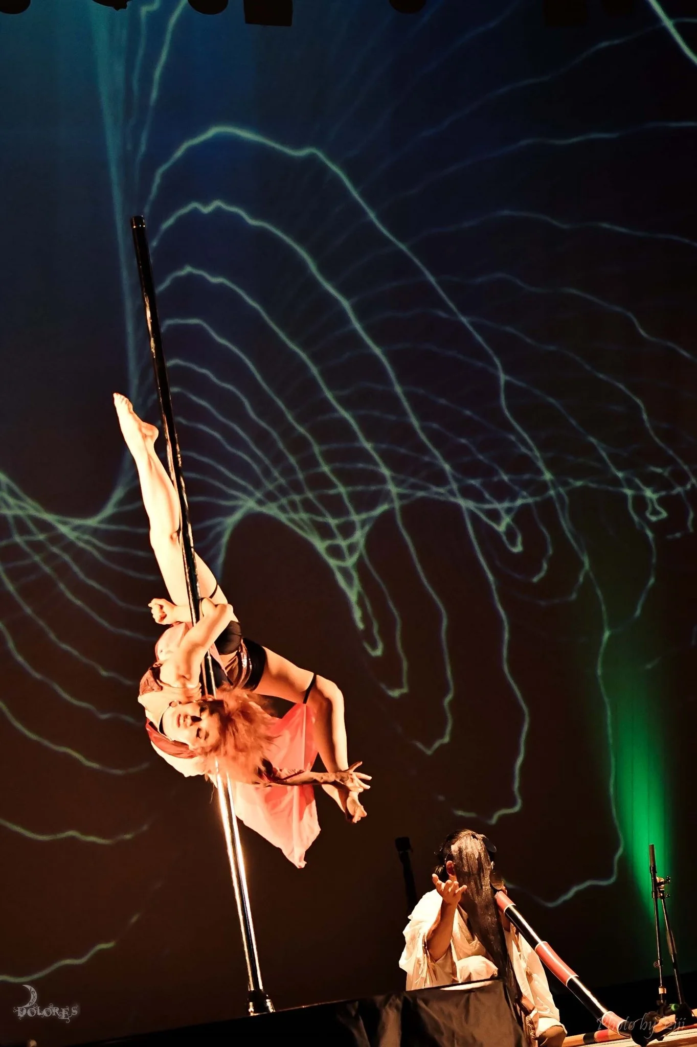 Cyber Zen by Tokyo Dolores, an interdisciplinary performance combining pole dance, visual projection, and live didgeridoo. The work explores the possibility of coexistence between digital technology and the Zen concept of emptiness and stillness.