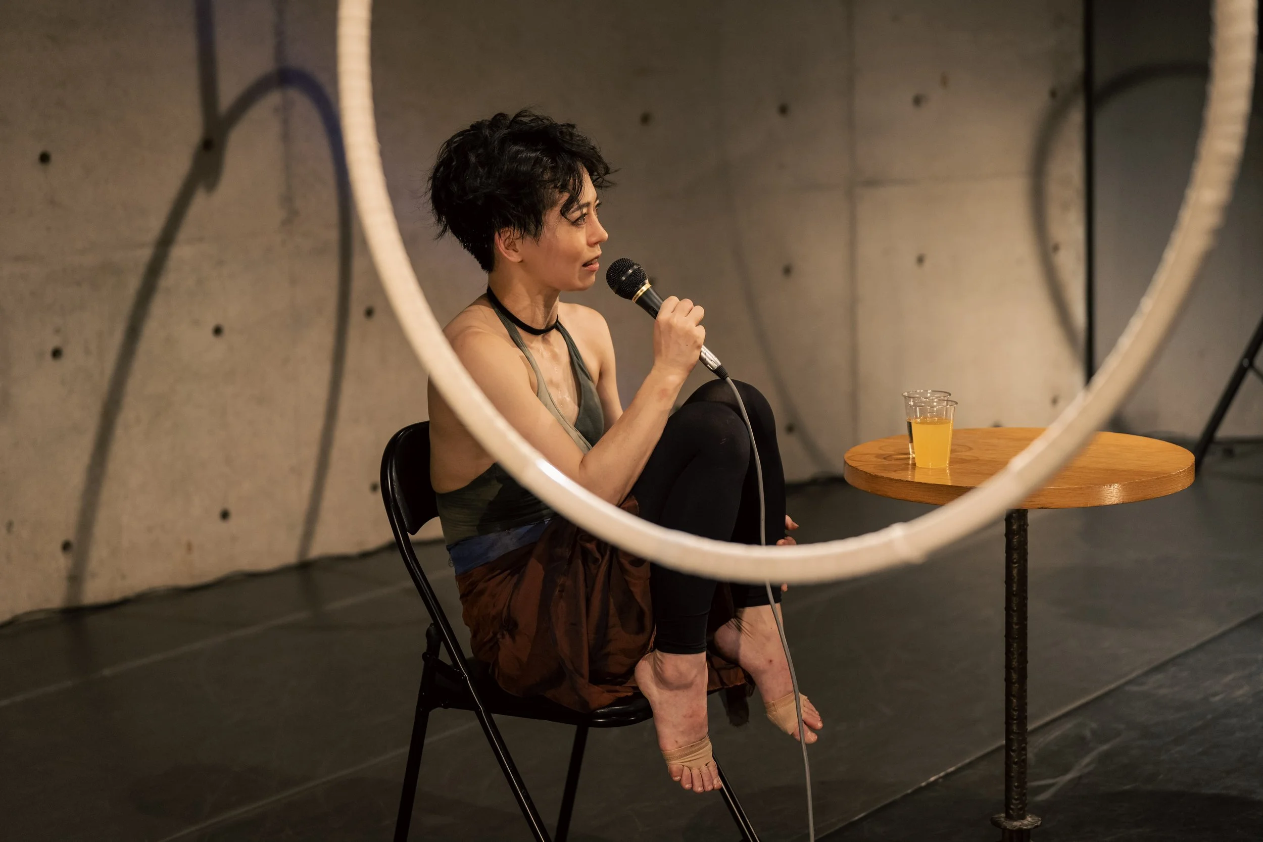 Cay Izumi speaking during an artist talk on performance, movement, and creative direction.
