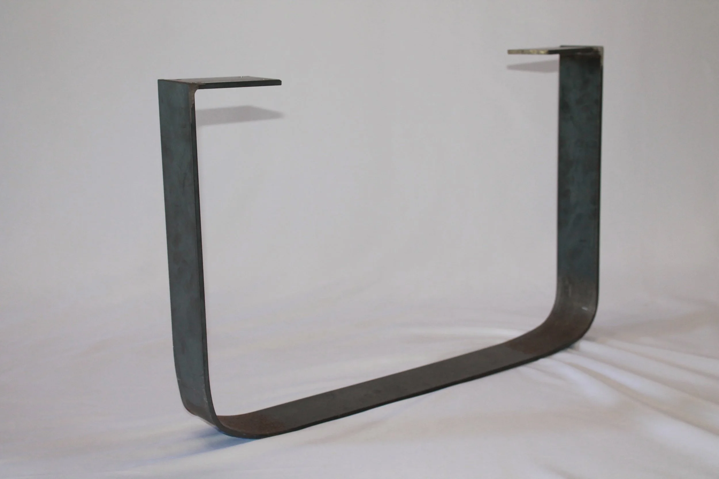 A metal C-shaped object against a light gray background.