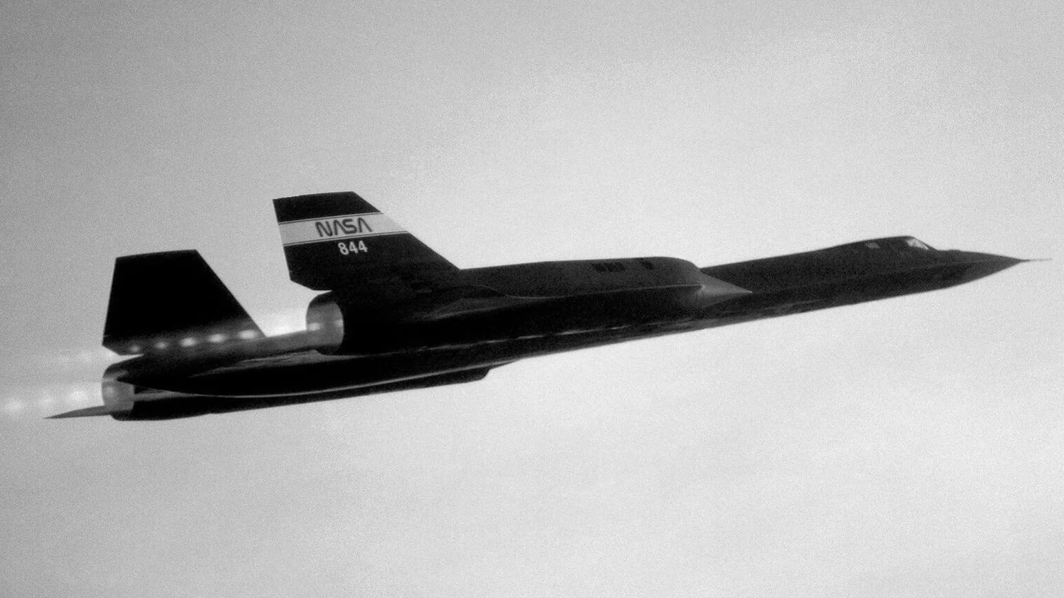A NASA experimental aircraft flying in the sky in black and white.