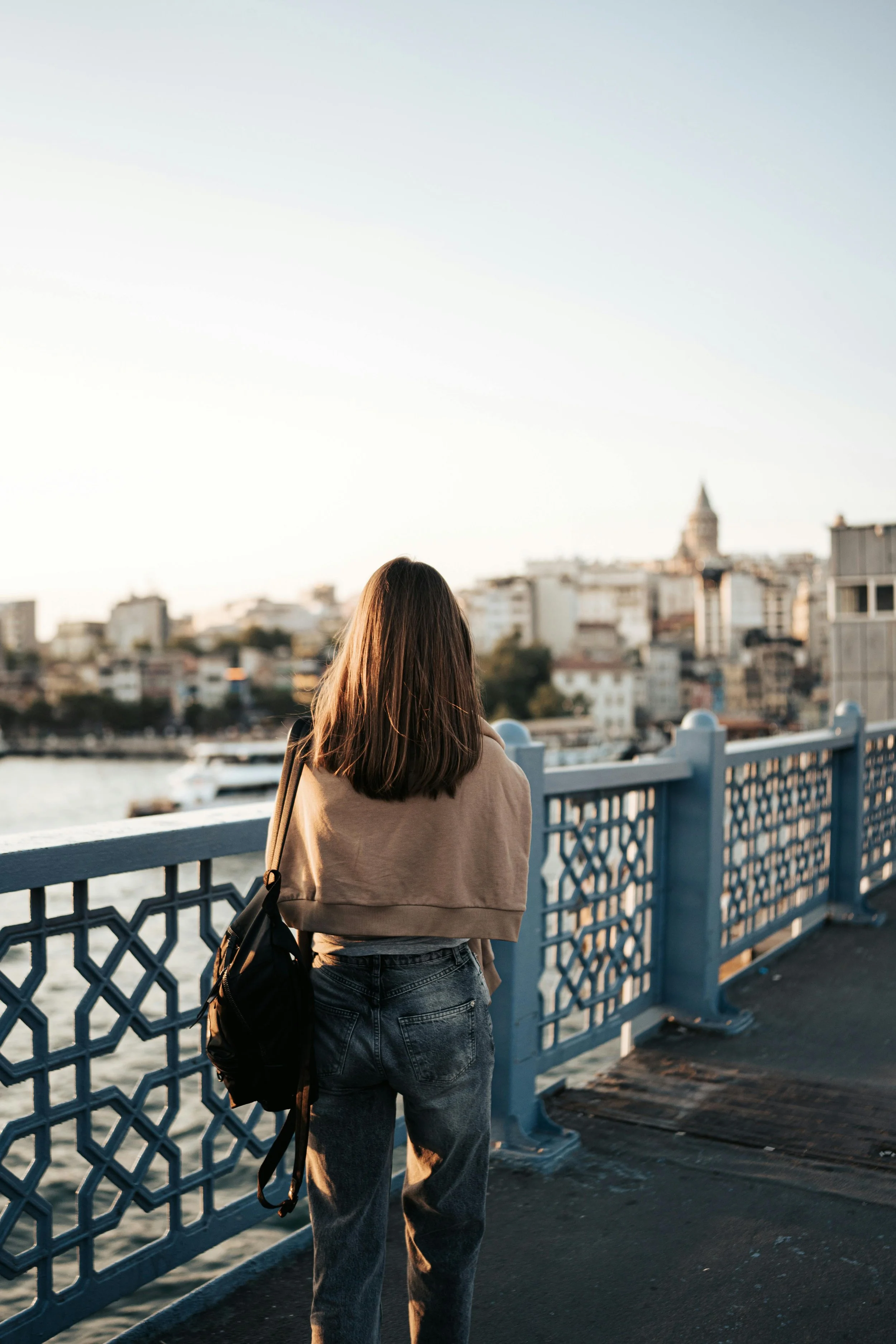 Girl walking on bridge to the city