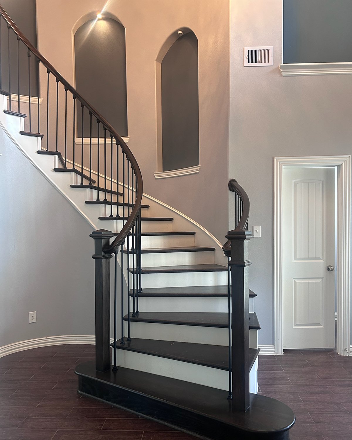 before image of dated foyer stairs with alcoves in blue tones