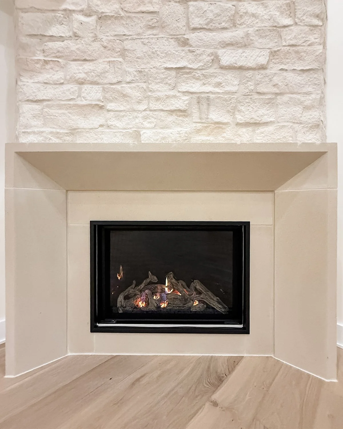Modern organic fireplace, surrounded by neutral tile and stone.