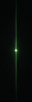Green laser beam emitting from a source in a dark environment