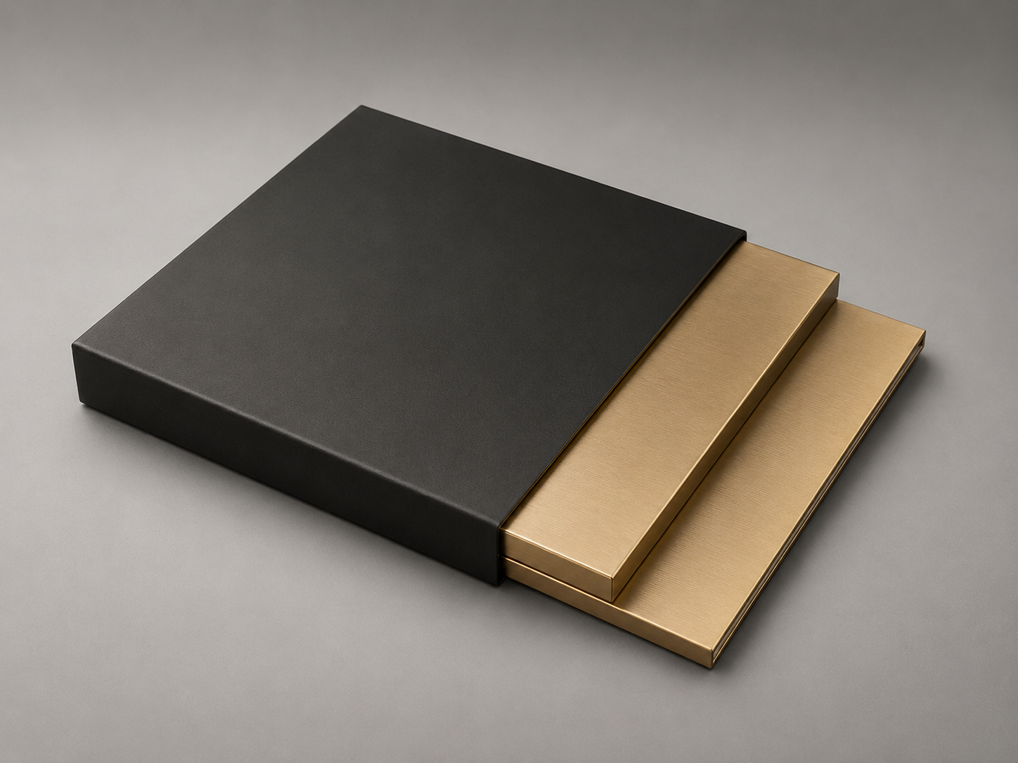 Two gold-colored magnetic clips stacked inside a black box on a gray background.