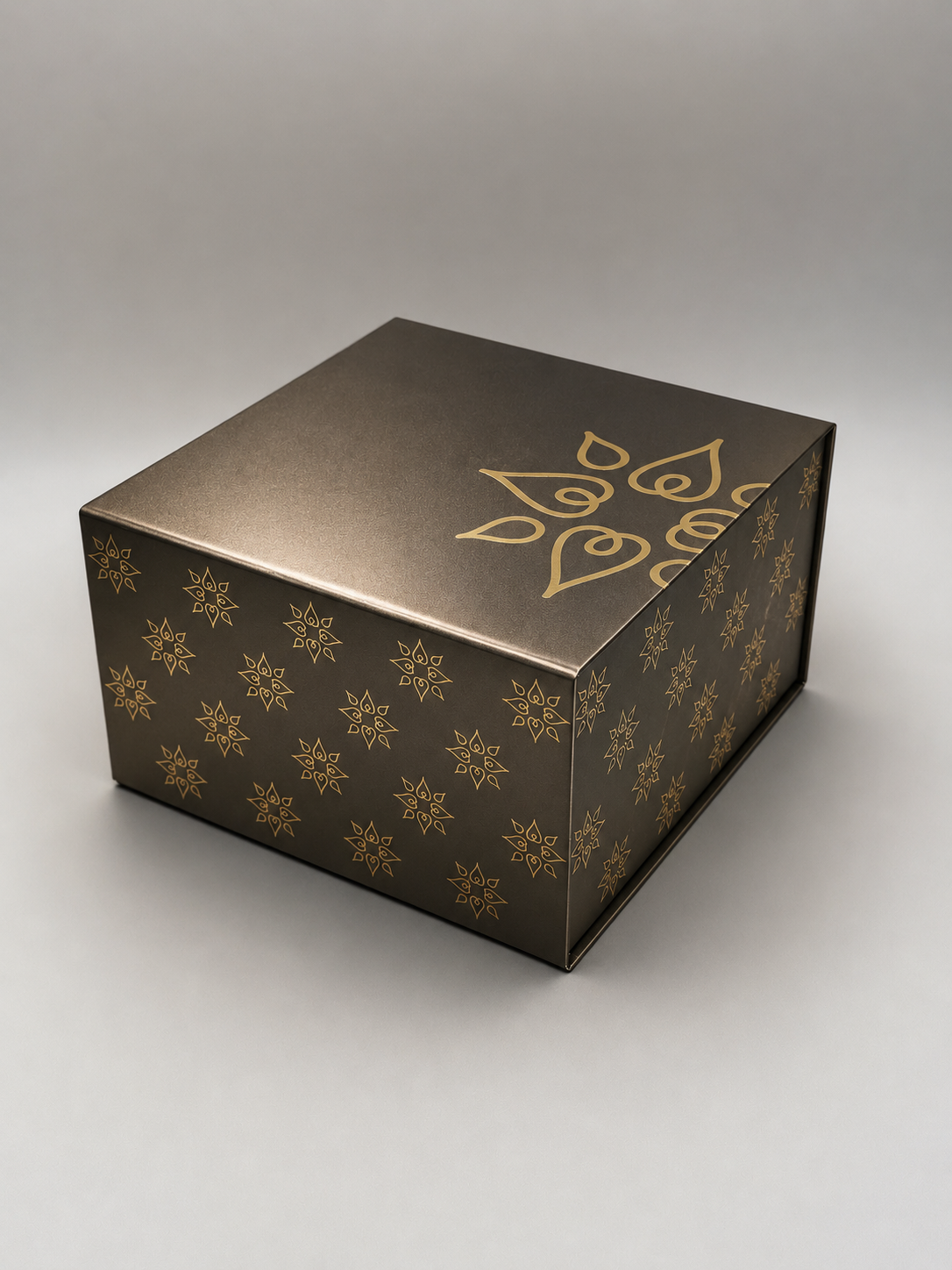 Black box with gold decorative pattern, lying on a light gray surface.