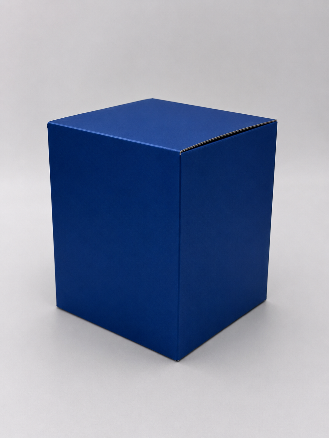 A plain, solid blue rectangular box with a closed top, placed on a white surface with a light gray background.