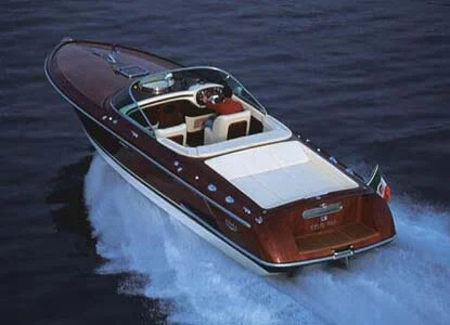 A luxury speedboat moving at high speed on open water.